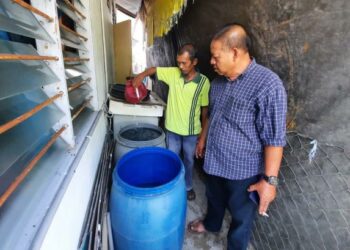 JAAFAR Darus (kiri) bersama Azmi Mat Desa menunjukkan tong air yang digunakan untuk menyimpan air berikutan masalah gangguan  bekalan air di Taman Camar Putih, Selama, Bandar Baharu, Kedah. - UTUSAN/AZAHAR HASHIM