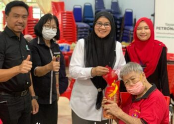 SABARIAH Saidan (tiga dari kiri) menyampaikan biskut bertemakan perayaan Tahun Baharu Cina kepada keluarga golongan kurang bernasib baik sempena Program Sentuhan Kasih Festive Tahun Baharu Cina di Bentong, Pahang.