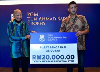 ARIFF Tuah (kanan) mewakili keluarganya menyampaikan sumbangan RM20,000 kepada wakil Yayasan Pusat Pengajian Al-Quran di Saujana Golf & Country Club, Shah Alam, hari ini.
