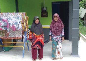 JAMALIAH Kassim (kiri) dan Saadiah (kanan) dihadapan rumah mereka di Kampung Mambang Berulang, Temerloh, Pahang.