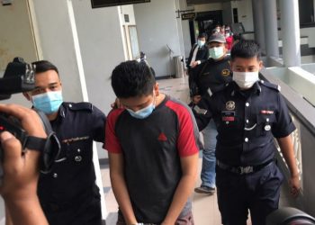 MD. Syafrizan Salleh (tengah) diiringi anggota polis selepas dijatuhkan hukuman penjara 14 hari dan denda RM1,000 oleh Mahkamah Majistret Melaka, hari ini.