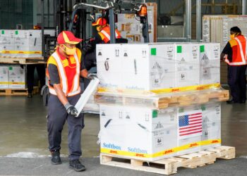 Petugas DHL mengendalikan   penghantaran vaksin Covid-19 jenis Pfizer Biontech sumbangan Amerika Syarikat yang baru tiba di tanah air di Kompleks Raya, Subang Jaya, semalam.  - UTUSAN/AMIR KHALID