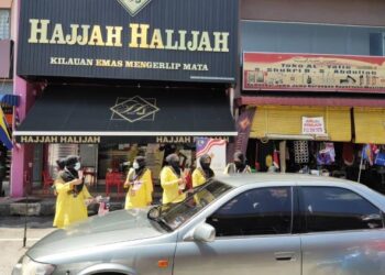 KAKITANGAN kedai emas Hajjah Halijah mengedarkan 200 Jalur Gemilang sempena sambutan Hari Kebangsaan di Jalan Medan, Kangar, Perlis. - UTUSAN/NAZLINA NADZARI