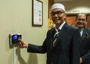 MOHD. Shukri Ramli mengimbas cap jari pada alat perakam waktu sebagai sombolik memulakan tugas di pejabat Menteri Besar di Kompleks DUN Kangar, Perlis.- FOTO/ASYRAF MUHAMMAD