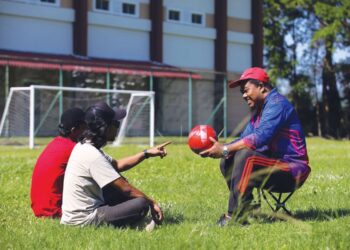 AZHAR Darus (kanan) mengimbau kenangan bersama bekas anak muridnya dari STB yang juga pemain bola sepak sekolah pada 1997 ketika beliau menjadi jurulatih di SK Sena, Kangar, Perlis. - MINGGUAN/SHAHIR NOORDIN