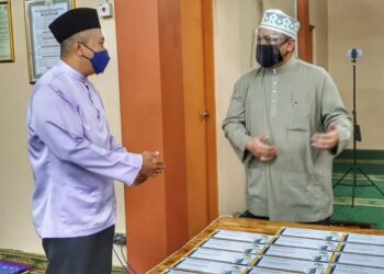 TUANKU SYED FAIZUDDIN PUTRA JAMALULLAIL (kanan) menyerahkan sumbangan zakat MAIPs di Masjid Al Islah, Ngulang, Arau, Perlis hari ini.- UTUSAN