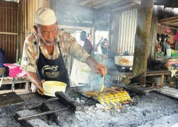 MUSA Hashim membakar ikan yang menjadi menu kegemaran pelanggan terdiri daripada pelajar IPT di kedainya di Pauh, Arau, Perlis. - UTUSAN/IZLIZAN OTHMAN