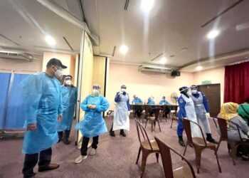 AZMAN MOHD YUSOF (kiri) meninjau proses pemberian vaksin di Program Vaksinasi Covid-19 Khas Tanpa Janji Temu di Hotel Putra Brasmana, Kuala Perlis, Perlis hari ini.- UTUSAN/NAZLINA NADZARI