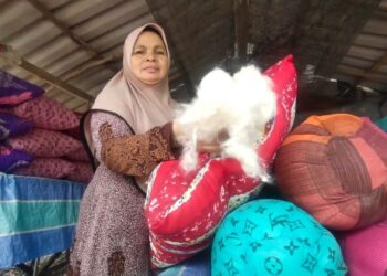 FATIMAH RAMLI antara pengusaha bantal kekabu yang masih bertahan sejak 30 tahun lalu di Batu 19, Jalan Padang Besar, Perlis hari ini.- UTUSAN/SYED AZLAN SAYID HIZAR