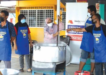 Penduduk bergotong-royong bersama-sama wakil Era Foods MY mengacau bubur lambuk dalam program Kongsi Berkat Bubur Lambuk dan diedarkan secara percuma kepada orang ramai di Dewan Orang Ramai, Kampung Tengah, Kuala Perlis semalam.
