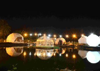 PENGUNJUNG melihat replika bulan yang memantul ke dalam tasik di The Wheel Estate Campsite yang berkonsepkan 'Glamping' pertama di Perlis, di Belukar Lenga, Chuping, Perlis. - UTUSAN/IZLIZAN OTHMAN