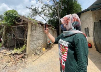NORHAYATIE Osman terpaksa keluar dari kawasan rumahnya untuk mendapatkan kelajuan internet yang lebih baik di Kampung Seri Kesinai, Batu 19, Padang Besar, Perlis. – UTUSAN/NAZLINA NADZARI