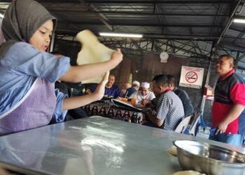 TELATAH comel Yusra Asna Ruslin menebar roti canai membantu bapanya terus mendapat perhatian ramai yang tidak putus-putus mengunjungi kedai mereka di kedai makan dan minuman Uwita Enterprise di Beseri, Padang Besar. -  UTUSAN/SYED AZLAN SAYID HIZAR