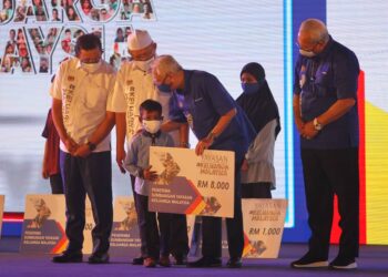 ISMAIL Sabri Yaakob (dua kanan) menyerahkan replika cek kepada seorang kanak-kanak yang menerima sumbangan dari Yayasan Keluarga Malaysia semada Jelajah Aspirasi Keluarga Malaysia di pekarangan Stadium Sultan Muhammad IV, Kota Bharu, Kelantan hari ini. - UTUSAN/ZULHANIFA SIDEK