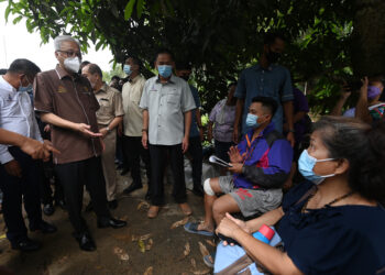 ISMAIL Sabri Yaakob berbual dengan mangsa kejadian tanah runtuh di Kampung Madsiang, Penampang, Sabah, semalam.– IHSAN JABATAN PERDANA MENTERI