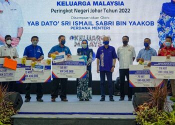 ISMAIL Sabri Yaakob (empat dari kiri) bersama Menteri Perpaduan Negara, Datuk Halimah Mohamed Sadique (lima dari kiri) dan para penerima Geran Rukun Tetangga pada majlis penyampaian Geran Rukun Tetangga Komuniti Sejahtera Keluarga Malaysia Peringkat Negeri Johor Tahun 2022 di Kompleks Sukan Komuniti, Felda Lok Heng, Kota Tinggi, Johor, hari ini. - FOTO/FARIZ RUSADIO