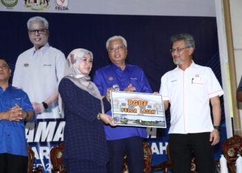 ISMAIL Sabri Yaakob menyerahkan dokumen projek Perumahan Generasi Baharu Felda kepada wakil peneroka di Felda Lasah, Sungai Siput, Perak, semalam. – UTUSAN/MUHAMAD NAZREEN SYAH MUSTHAFA