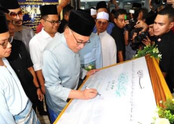 ANWAR Ibrahim menandatangani plak Masjid Kampung Melayu Majidee, Johor Bahru sebelum menunaikan solat Jumaat bersama-sama lebih 2,000 jemaah. - FOTO/RAJA JAAFAR ALI