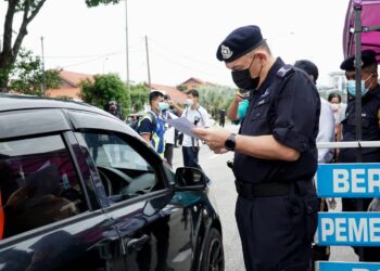 MIOR Faridalathrash Wahid memeriksa dokumen perjalanan pemandu kenderaan di SJR Jalan Raja Dr. Nazrin Shah di Ipoh hari ini.  - UTUSAN/ZULFACHRI ZULKIFLI