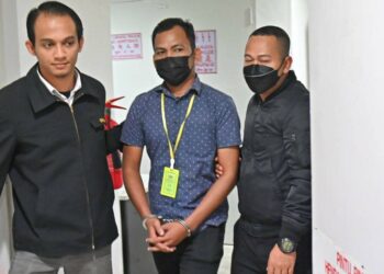 MOHD. Izzham Halim  (tengah) yang mengaku tidak bersalah terima rasuah dibawa keluar dari Mahkamah Sesyen, Kuala Terengganu, hari ini. - UTUSAN/PUQTRA HAIRRY ROSLI