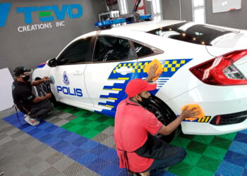 KAKITANGAN Pusat Cucian Kereta Asiawash membasuh kenderaan anggota barisan hadapan di Bayan Lepas, Pulau Pinang, semalam