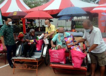 YEOH SOON HIN (kiri) pada program pemberian bakul makanan sumbangan One Hope Charity and Welfare kepada 80 penarik beca di Georgetown, Pulau Pinang hari ini.