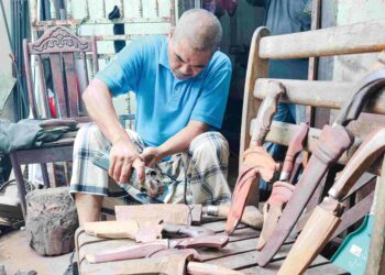 AZHAR Hamid menunjukkan pisau menyembelih serta melapah daging korban yang ditempah oleh pelanggannya di bengkel besi miliknya 
di Pekan Darat, Telok Air Tawar, Pulau Pinang baru-baru ini.