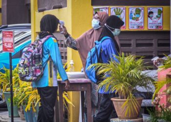 SEBAHAGIAN murid-murid tahun satu hingga enam Sekolah SK Permatang Janggus  yang hadir pada hari persekolahan selepas diarahkan ditutup selama lapan hari sebelum ini memulakan persekolahan dengan kehadiran penuh, berikutan seorang guru wanita dan seorang murid positif COVID-19.-UTUSAN/AMIR IRSYAD OMAR