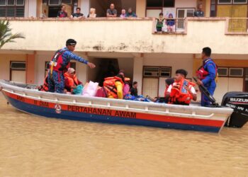 ANGGOTA APM membantu memindahkan mangsa banjir di PPS Sekolah Kebangsaan Durian Mentangau yang dinaiki air ke PPS SK Felda Kerteh 3, Dungun, Terengganu, hari ini. - UTUSAN/NIK NUR IZZATUL HAZWANI NIK ADNAN