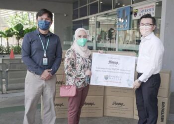 DUA pegawai Perubatan PPUM menerima sumbanhan 10,000 pelitup muka daripada wakil Anggun Kirana di Petaling Jaya hari ini.
