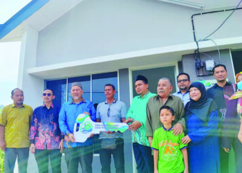 ROSLAN Ahmad (tiga dari kiri) ketika menyampaikan replika kunci kepada pemilik rumah inapan kasih Pulau Pinang, di Kampung Teluk Kambar, Bayan Lepas baru-baru ini.