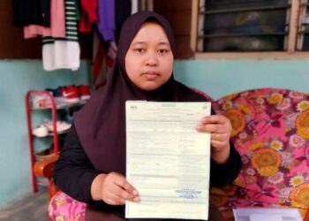 NOORSAM Mairan menunjukkan sijil pendaftaran kematian bapanya yang dikeluarkan Hospital Teluk Intan ketika ditemui di Kampung Air Hitam di Teluk Intan, Perak semalam. - UTUSAN/AIN SAFRE BIDIN