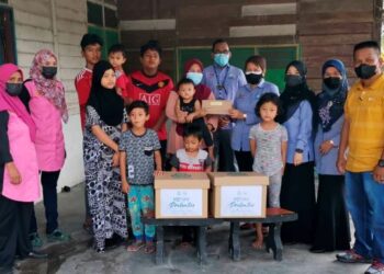 RAK Boon Tan Rat (empat dari kanan) menyerahkan bayaran faedah Perkeso kepada Siti Norlia Ramsah di Sungai Manik dekat Pasir Salak, Perak. - UTUSAN/AIN SAFRE BIDIN