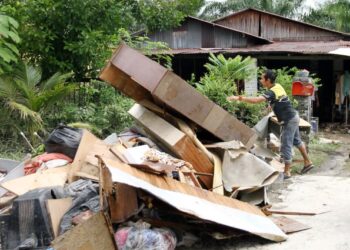 PENDUDUK membersihkan rumah yang dilanda banjir kelmarin ketika tinjauan di RPT Chepor di Ipoh, semalam. –UTUSAN/MUHAMAD NAZREEN SYAH MUSTHAFA