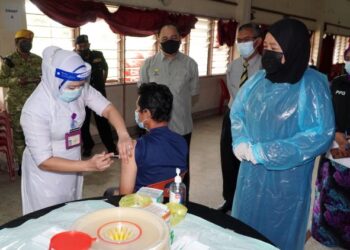 WAN Norashikin Wan Noordin (kanan) meninjau pemberian vaksin Covid-19 kepada seorang gelandangan PPG Sementara di Wisma Persatuan Bulan Sabit Merah, Ipoh, Perak, hari ini. -  FOTO/ZULFACHRI ZULKIFLI