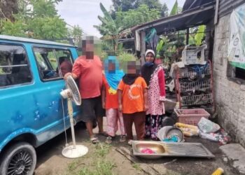 JUMAH Ibrahim (kanan) bersama suami dan dua anaknya di rumah sewa yang daif dan menjadi tempat pengumpulan barang terpakai di Teluk Intan, Perak. – FOTO/AIN SAFRE BIDIN