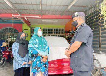 A. ASMADI Abdul Aziz berbual dengan Khadijah Din (tengah) ketika melawat keluarga berkenaan di Chemor, Ipoh, Perak.