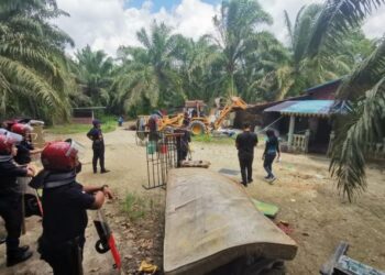 ANGGOTA FRU memantau kerja meroboh rumah peneroka selepas tanah tersebut dipajak oleh sebuah syarikat di Kampung Air Tenang, Tukang Sidin dekat Pasir Salak semalam. - UTUSAN/AIN SAFRE BIDIN