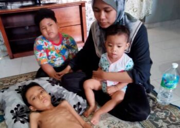 NOORSHAKILA Mohamad Noor Jalali menjaga anaknya Shaz Afif Firash berusia lapan tahun yang  berbaring akibat menghidap penyakit radang usus ketika ditemui di Teluk Intan semalam. – UTUSAN/AIN SAFRE BIDIN