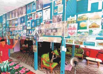 ZAINAL Abidin Ismail menunjukkan koleksi gambar lama yang 
terdapat di galerinya di Kampung Rungkup Kecil di Bagan Datuk, 
Perak – UTUSAN/AIN SAFRE BIDIN