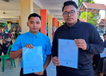 MUHAMMAD Khirizuran Mohd Khir (kiri) dan Muhammad Khirizuran Mohd Khir menunjukkan keputusan SPM yang mereka peroleh di Sekolah Menengah Kebangsaan Toh Muda Abdul Aziz Sungai Siput (U). - UTUSAN/SAYED HESHAM IDRIS