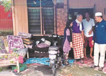 NADZIRUDDIN  Mohamed Bandi (kanan) menziarahi Abdul Samad Md Maarus yang menderitai sakit kulit dan rumahnya yang usang di Kampung Padang Tembak, Teluk Intan baru-baru ini. – UTUSAN/AIN SAFRE BIDIN