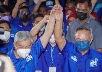 PENGERUSI Barisan Nasional (BN), Datuk Seri Dr. Ahmad Zahid Hamidi (kiri) bersama Hasni Mohammad mengangkat tangan ketika keputusan BN memenangi Pilihan Raya Negeri (PRN) Johor di Dewan Perhubungan UMNO. - UTUSAN/FARIZ RUSADIO