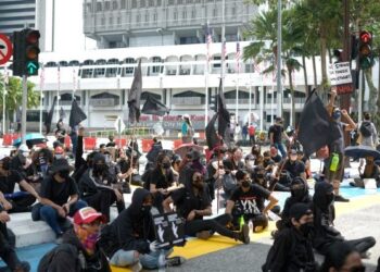 SEKUMPULAN peserta berpakaian hitam duduk di atas jalan raya ketika protes #Lawan di persimpangan Jalan Tun Perak dan Jalan Raja, Kuala Lumpur. – UTUSAN/MUHAMAD IQBAL ROSLI