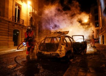 ANGGOTA bomba memadam kereta yang dibakar penyokong PSG di Champs-Elysees, Paris hari ini selepas pasukan itu kalah kepada Bayern Munich dalam final Liga Juara-Juara di Lisbon. - AFP