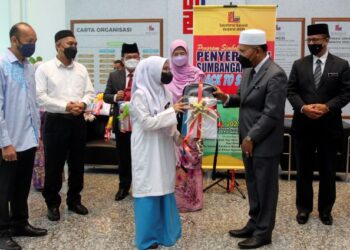 IDRIS Ahmad menyerahkan sumbangan kelengkapan sekolah untuk pelajar asnaf sempena sesi baharu persekolahan 2022/2023 di Kompleks Islam Putrajaya. - FOTO/FAISOL MUSTAFA