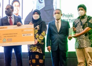 M. SARAVANAN (kiri) bersama Adham Baba menyampaikan hadiah kepada pemenang tempat pertama kategori orang awam kepada wakil dari D Athirah Magic Ruler pada Majlis Menandatangani (MoU) antara Perkeso dengan YIM di Menara Perkeso, Putrajaya. - FOTO/FAISOL MUSTAFA