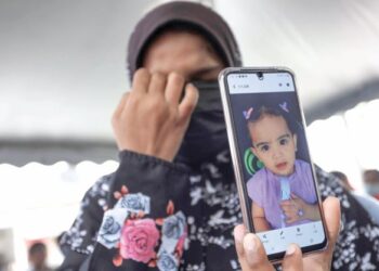 NURUL Aishah Mohamad Kassim menunjukkan gambar adiknya yang maut dilanggar bas sekolah di Taman Anggerik, Bandar Baru Salak Tinggi, Sepang, Selangor. - UTUSAN/FAISOL MUSTAFA