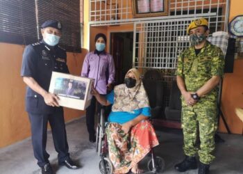 WAN KAMARUL AZRAN menyampaikan pek bungkusan kepada Norli Muhammad Sarip dalam Op Bantu di Taman Desa Merpati, Sepang, Selangor. UTUSAN/NUR SHARIEZA ISMAIL
