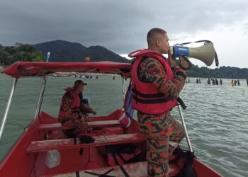 ANGGOTA bomba melakukan pengawasan terhadap pengunjung yang berjalan kaki ke Pulau Giam semasa fenomena air surut di Pulau Pangkor, hari ini. - UTUSAN/JBPM PERAK